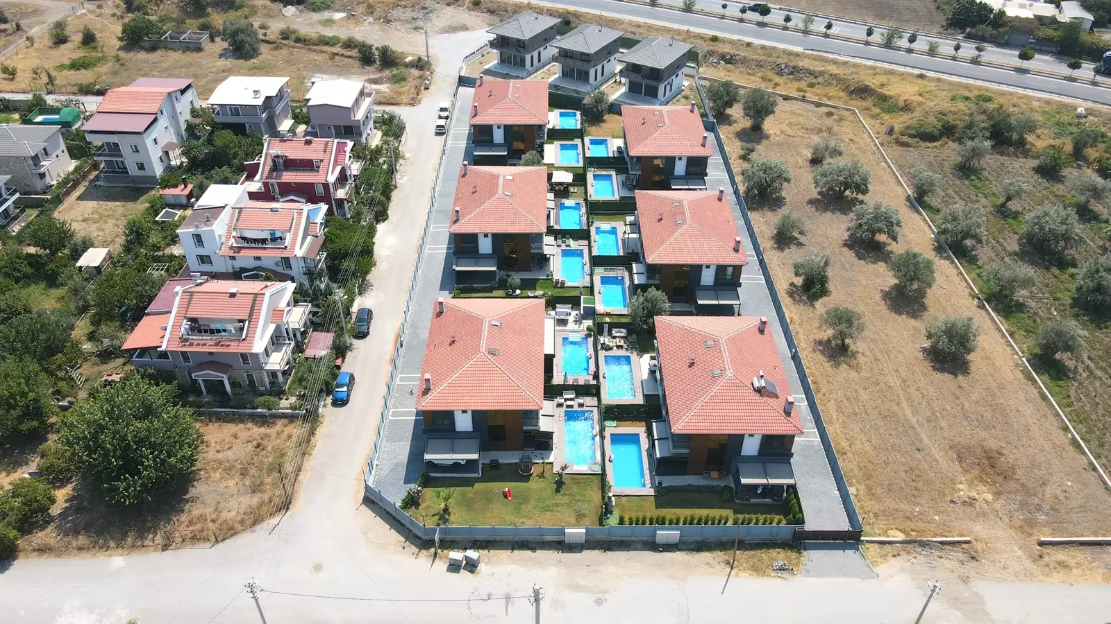 Elit Doğa sitesinin kuşbakışı görünümü — aynı hatta sıralı, tamamlanmış çok sayıda villa havuzu